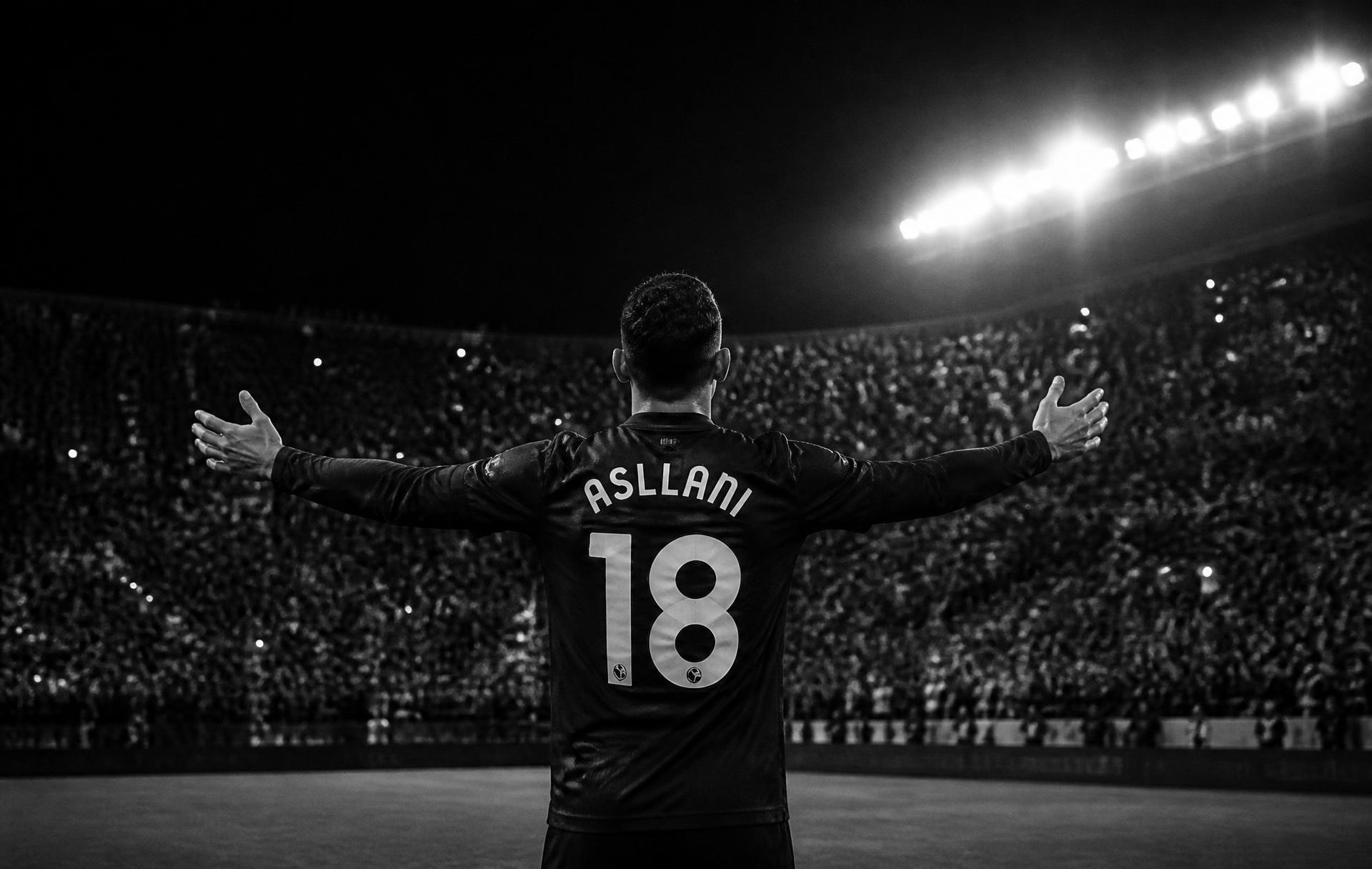 Kristjan Asllani standing before a floodlit stadium crowd