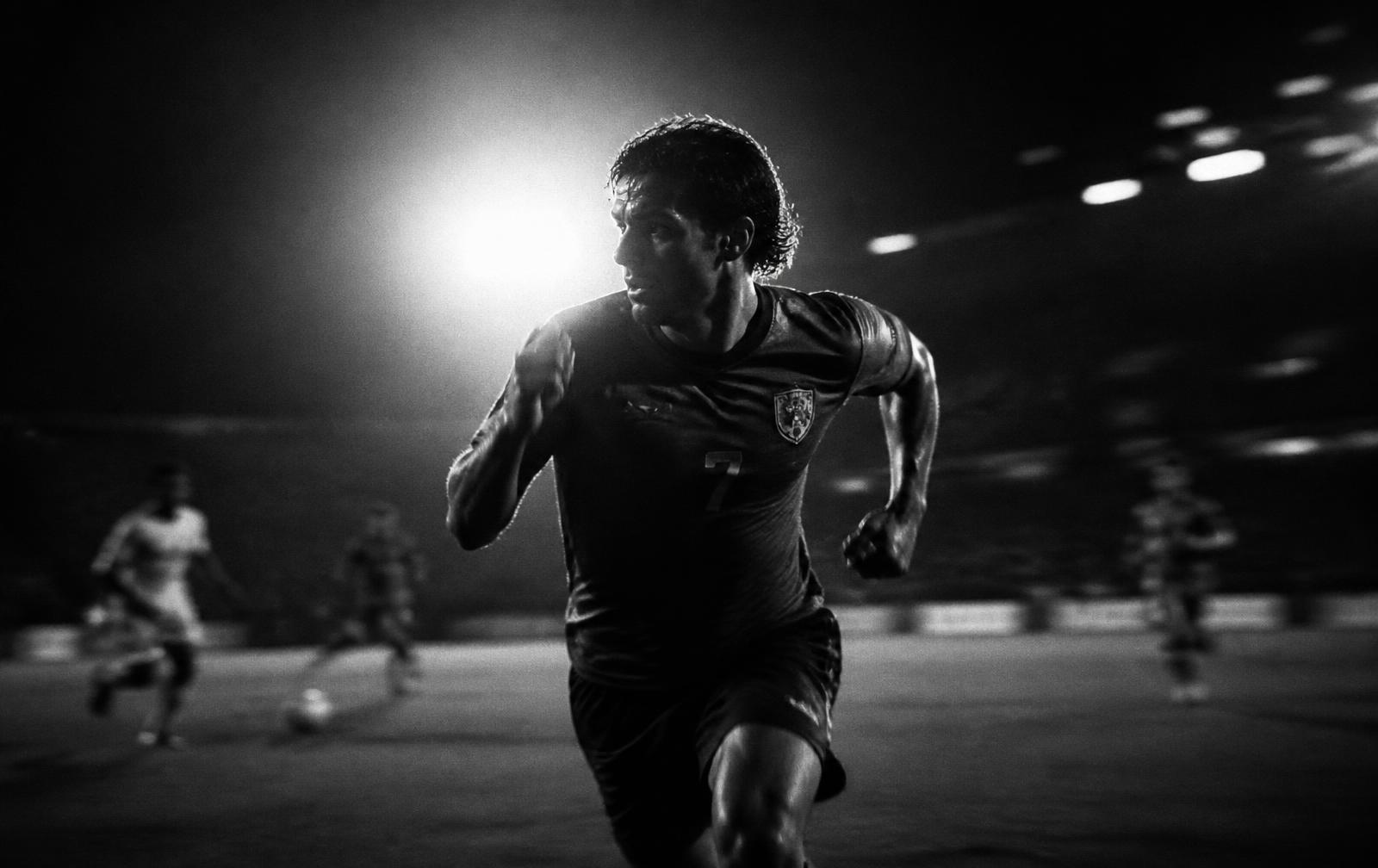 Player sprinting under floodlights